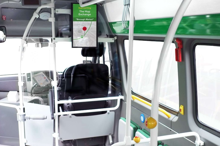 An interior shot of a bus, taken from behind the driver's seat.