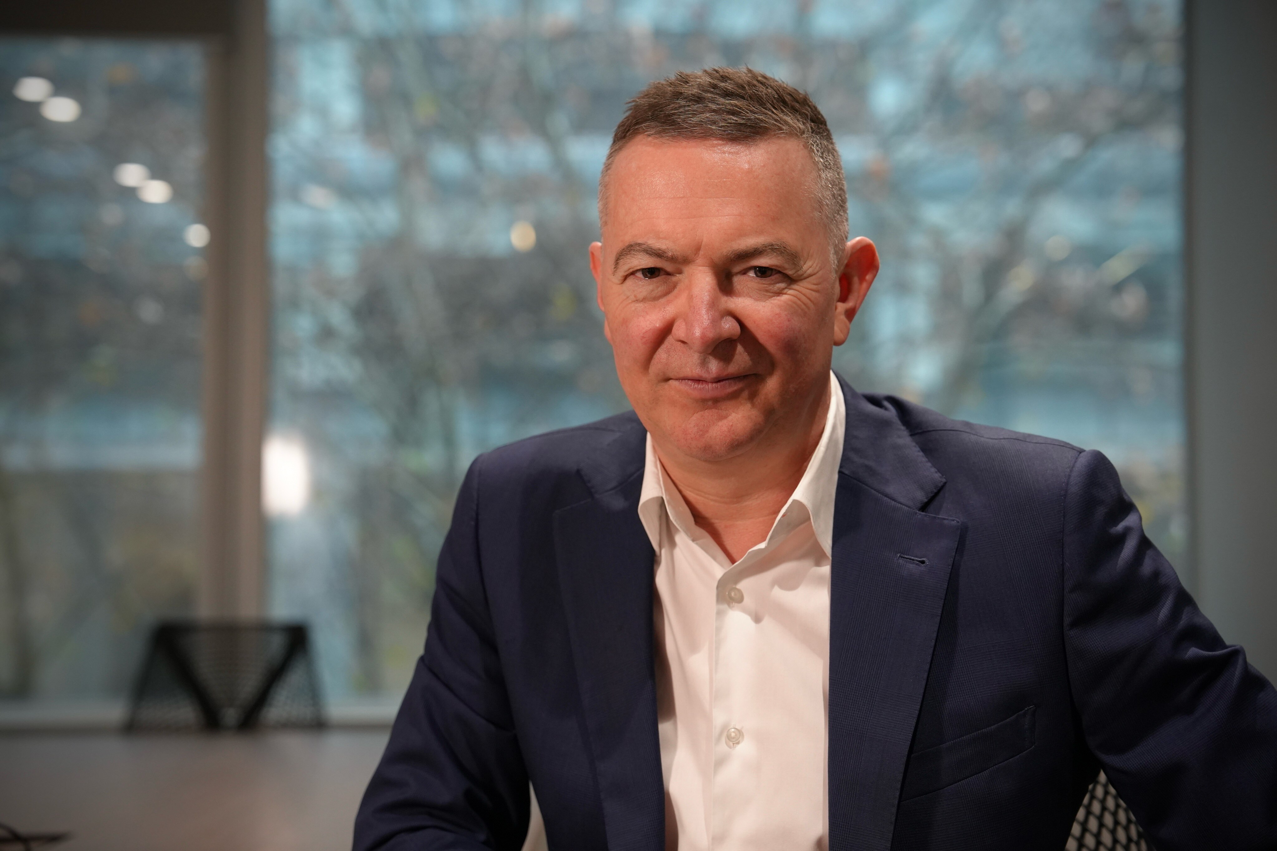 Un hombre con traje mira a la cámara.