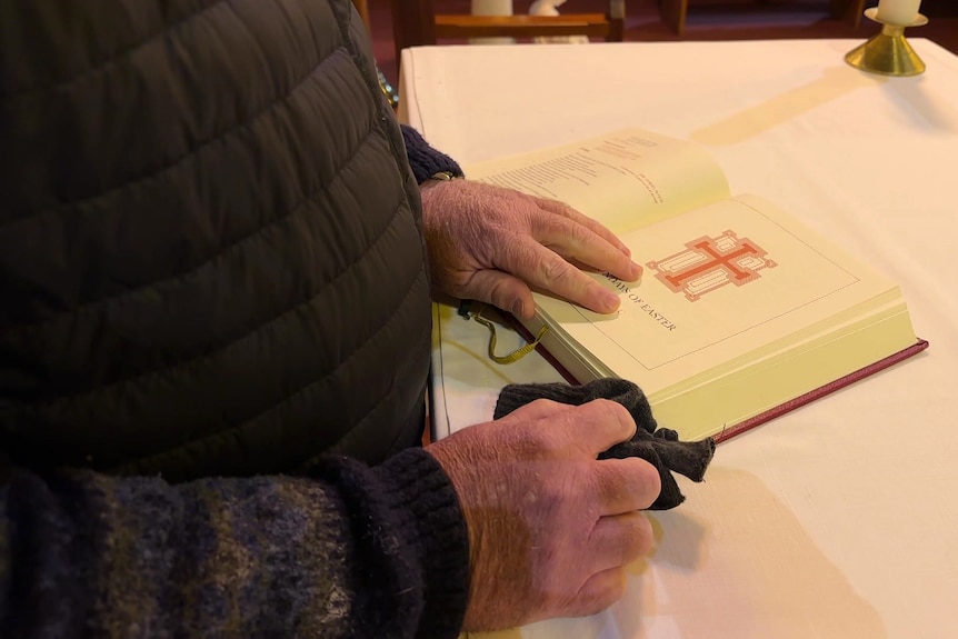 a priest with his hands on the bible