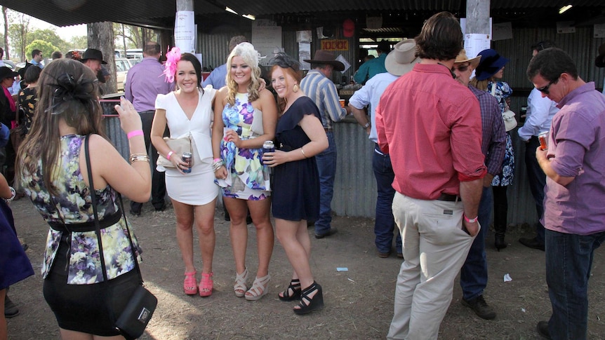 Girls have photo taken in front of bar at the Burrandowan Picnic Races.