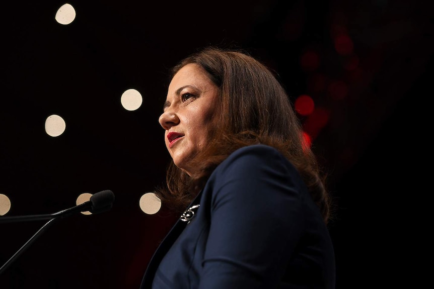 Queensland Premier Annastacia Palaszczuk stands behind a lectern while giving a speech.