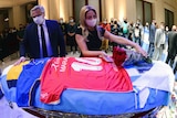 Argentina President Alberto Fernandez and first lady Fabiola Yañez stand over Diego Maradona's coffin in the presidential palace