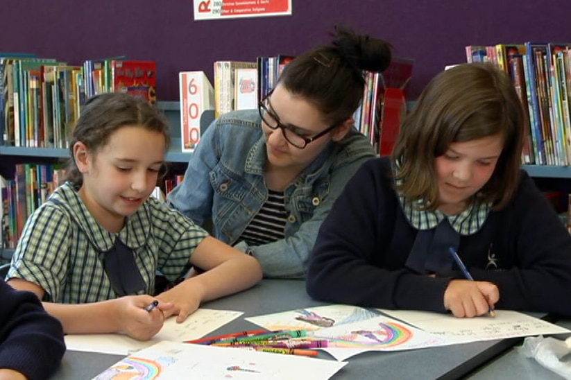 Teacher Ellen O'Brien in the classroom with two primary school children.