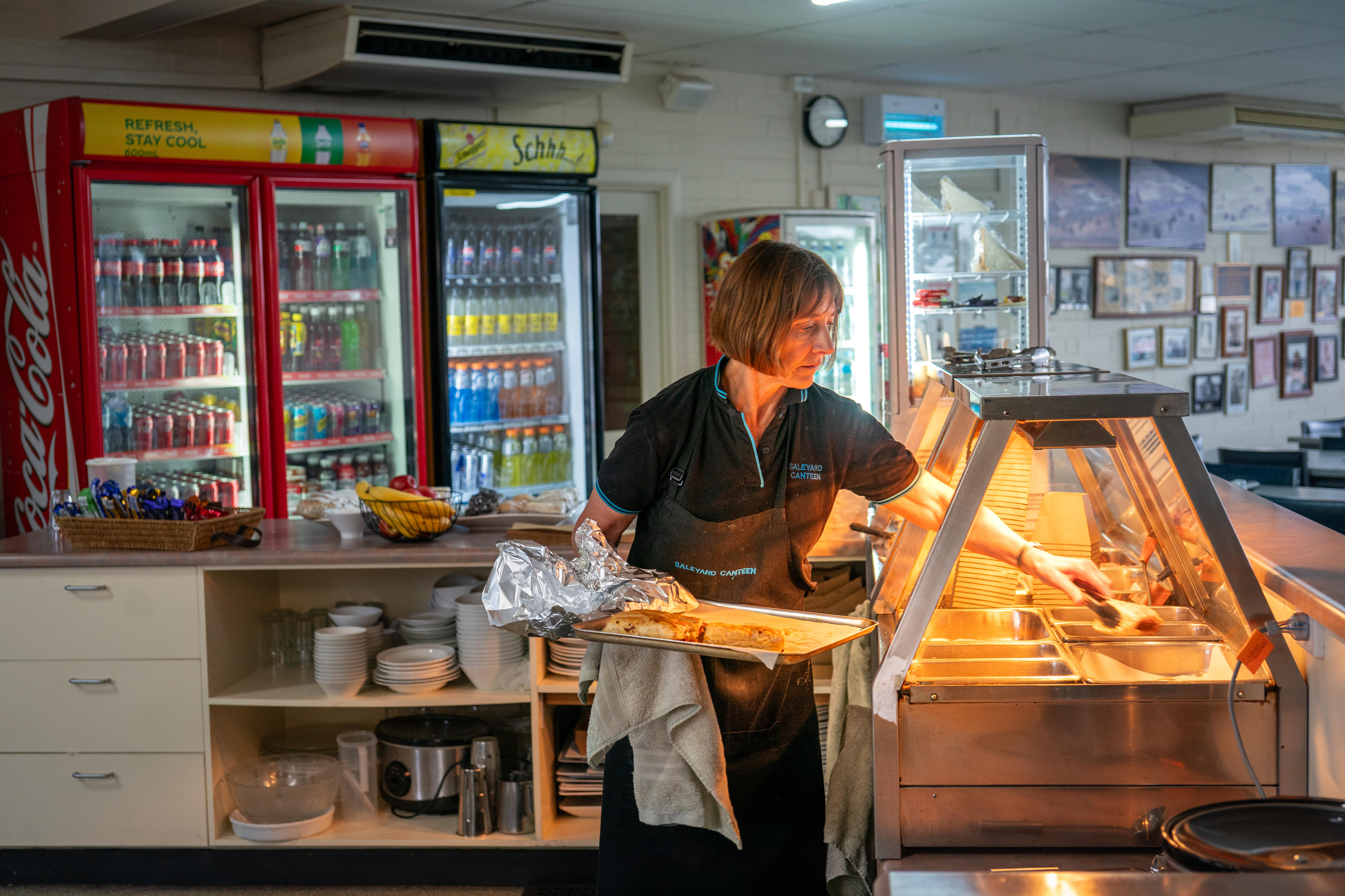 Una mujer pone rollos de salchicha en un calentador. 