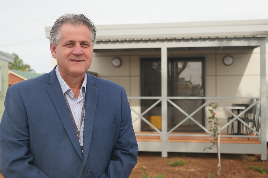 Evan Nunn stands in front of Bunbury's first tiny houses