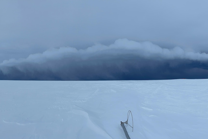 A very dark sky with a vast icy landscape