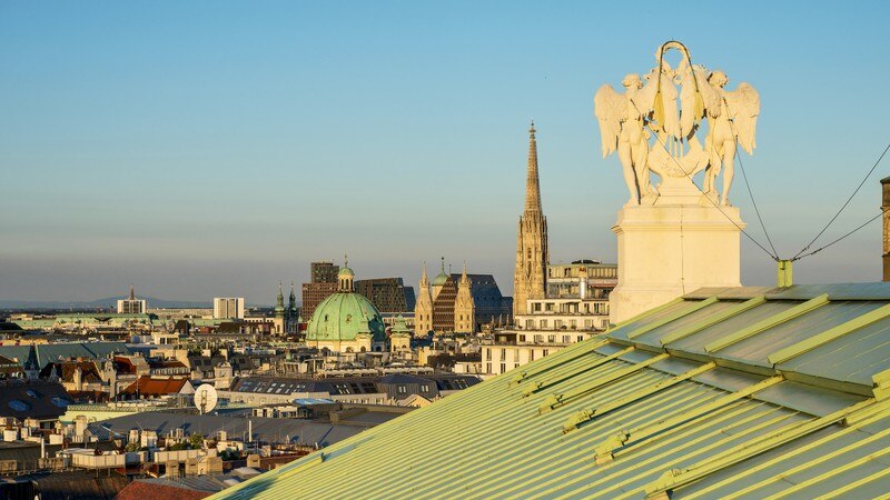 The city skyline of Vienna, Austria, looking over a rooftop.