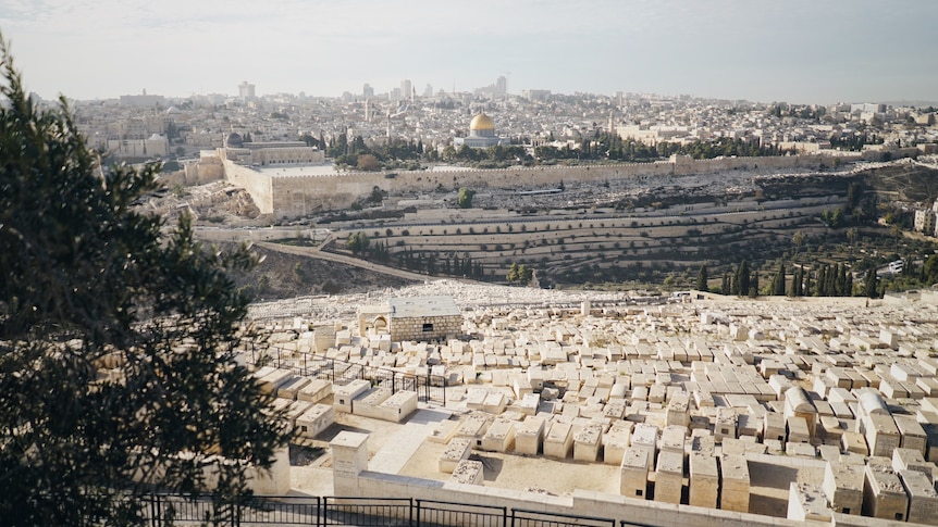 A cemetery in Jerusalem with the city and the dome of the rock behind it