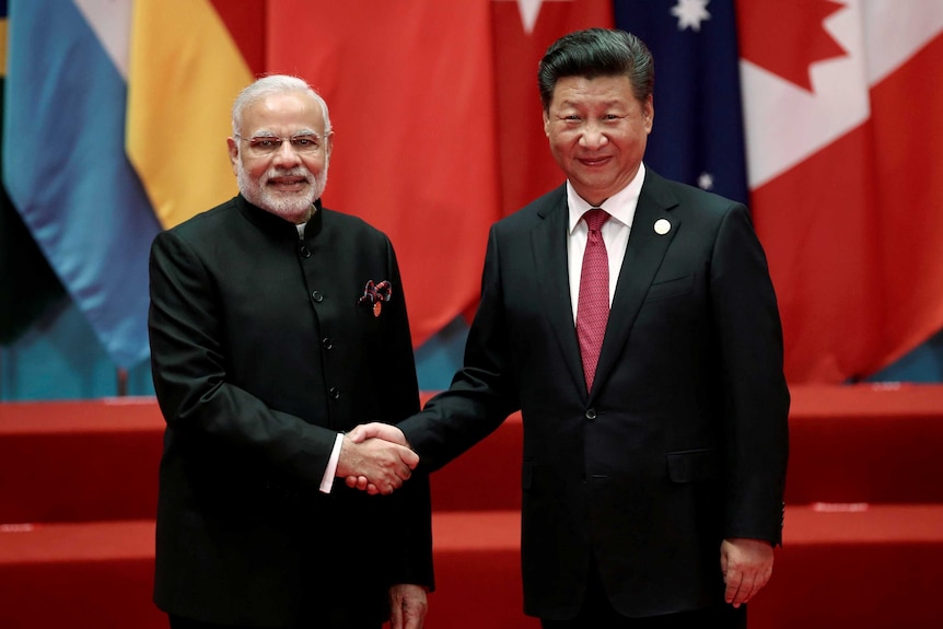 Chinese President Xi Jinping shakes hands with Indian Prime Minister Narendra Modi.
