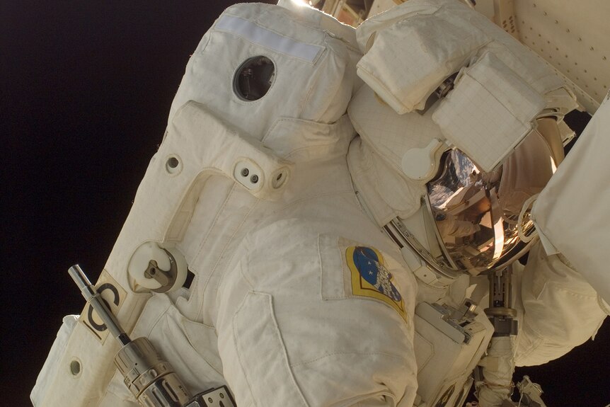 Close up image of a suited astronaut in space.