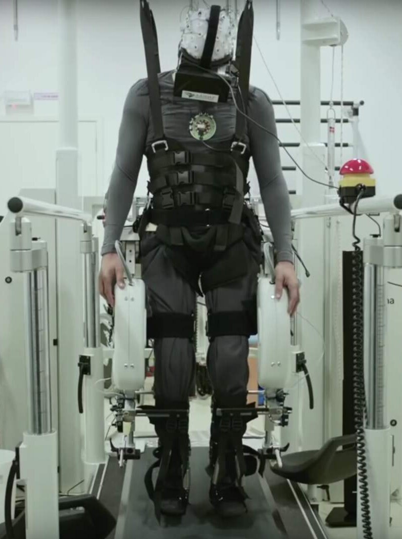 A person in a harness takes part in a study into helping paralysed people walk again.