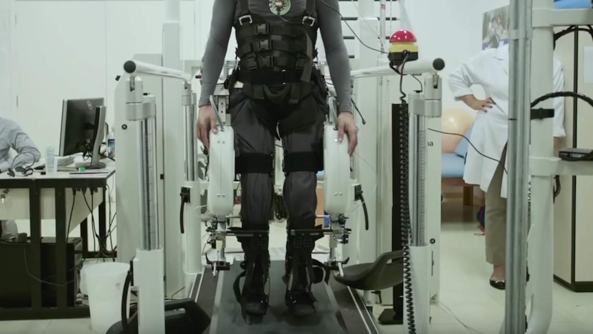 A person in a harness takes part in a study into helping paralysed people walk again.