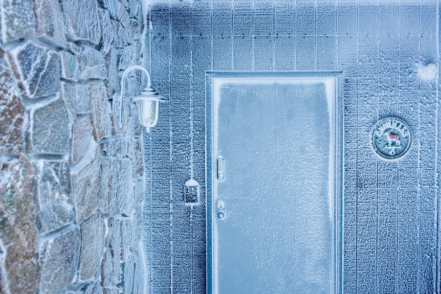 Ice coats the front door of an apartment.