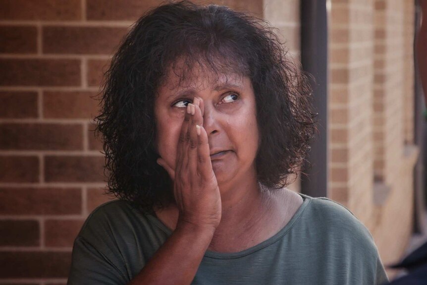 Aboriginal woman Lorna Haines wipes away tears.
