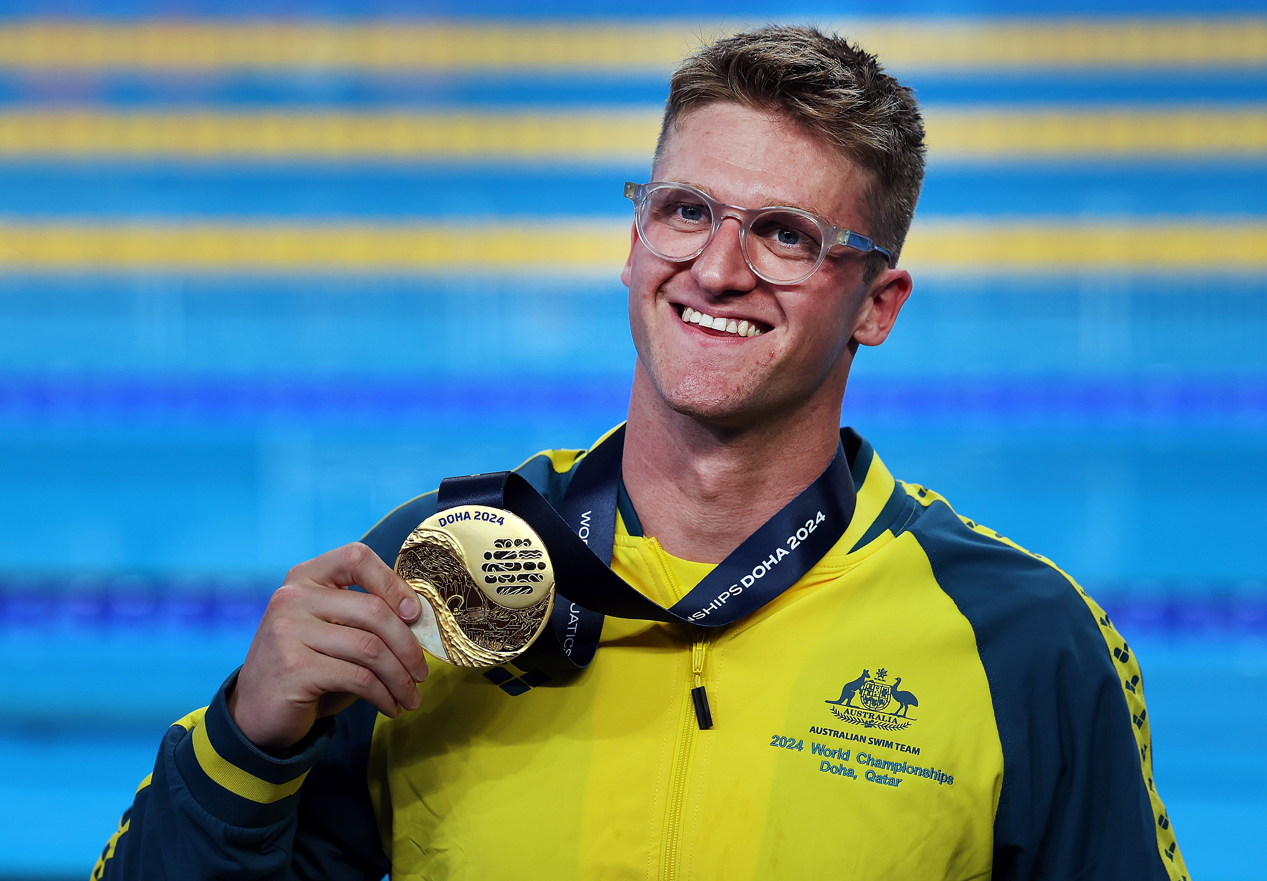 Sam Williamson smiles holding a gold medal