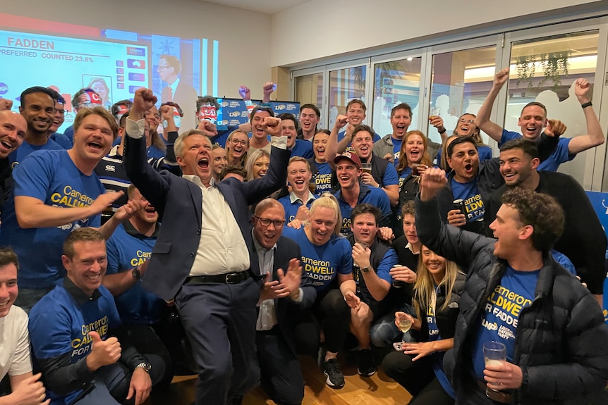 A group photo of Cameron Caldwell with supporters cheering