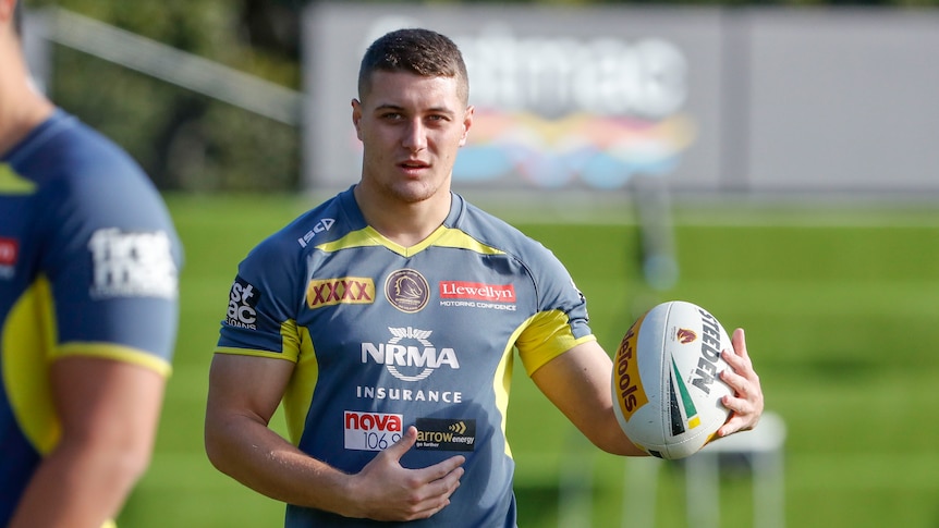 Troy Dargan holds a rugby ball while walking towards the camera.