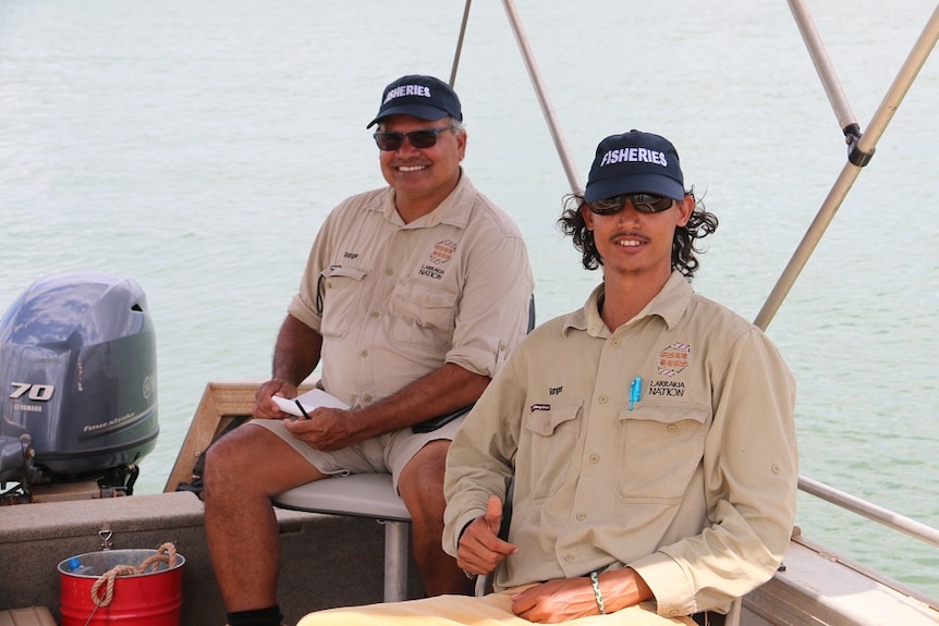 The pair sit on a boat