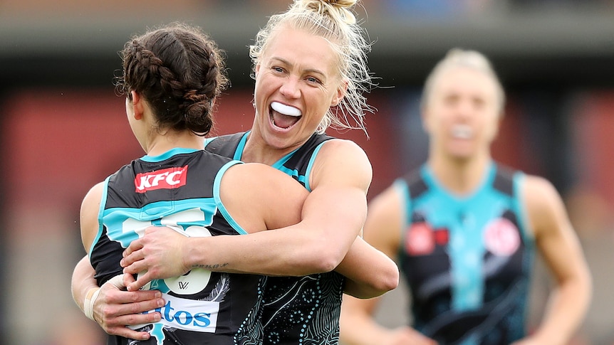 Erin Phillips smiles while hugging a teammate