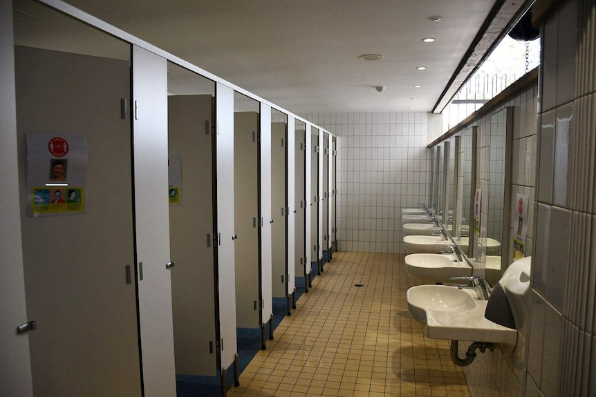 A row of shower cubicles and hand basins in a bathroom for boarders at Nudge College in Brisbane.