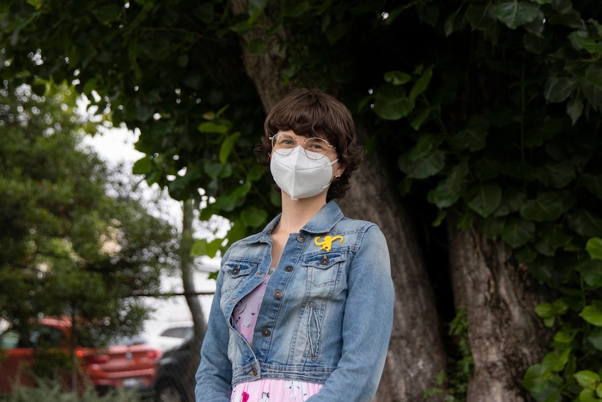 A woman in the garden, wearing a face mask.