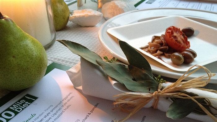 A place setting with a menu saying 100-mile diet
