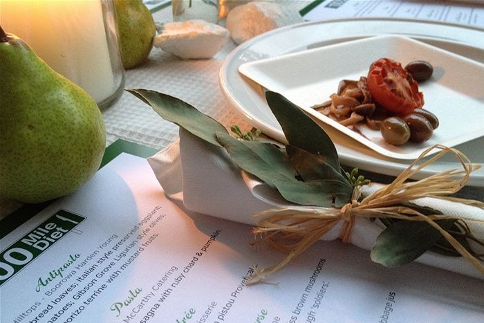 A place setting with a menu saying 100-mile diet