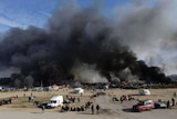 Thick smoke rises from amidst the tents after fires were started in the makeshift migrant camp.