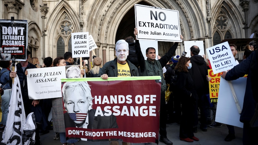 Protestors in front of church carry placards and signs in support of Julian Assange