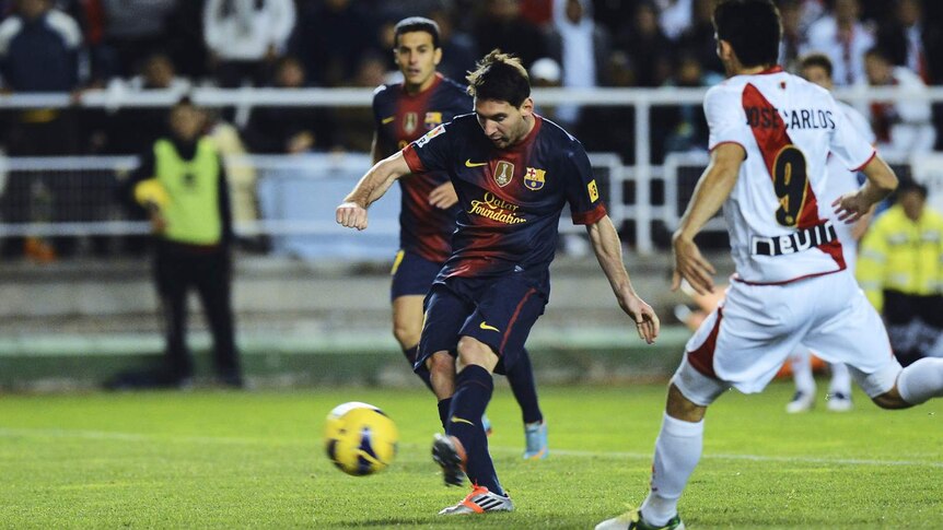 Lionel Messi scores his first of two goals for Barcelona against Rayo Vallecano.