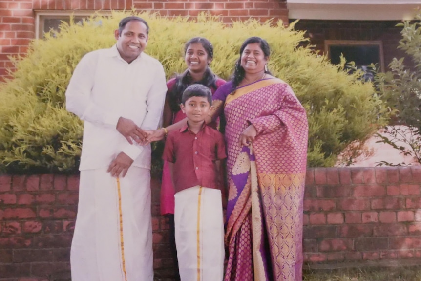 Two parents and their children dressed in Sri Lankan ceremonial dress.
