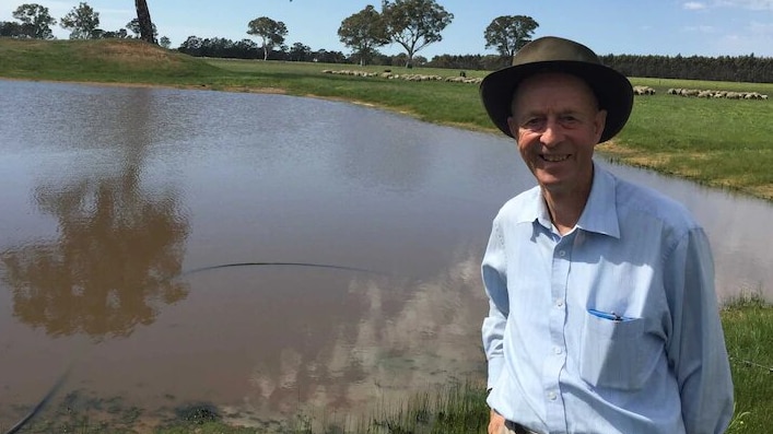 Dergholm farmer Murray Davis stands in front of a dam.