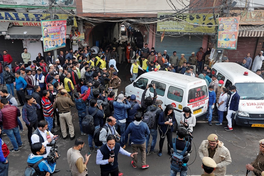 An ambulance driving through a large crowd of people