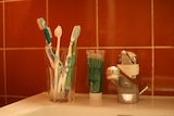 A collection of toothbrushes in a cup in a bathroom