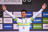 An Australian male cyclist raises his arms after being awarded a bronze medal at the world road cycling championships.