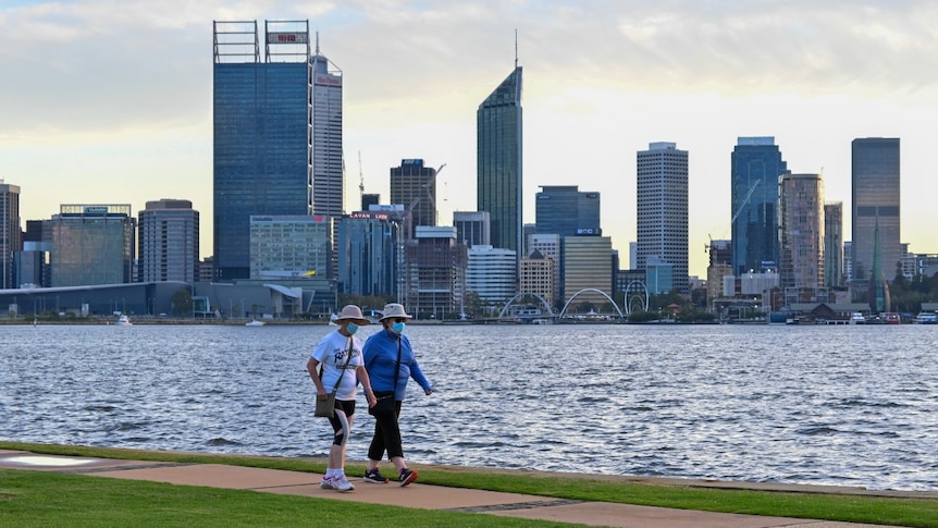 Two woman walking on South Perth foreshore with the Perth city skyline in the background.