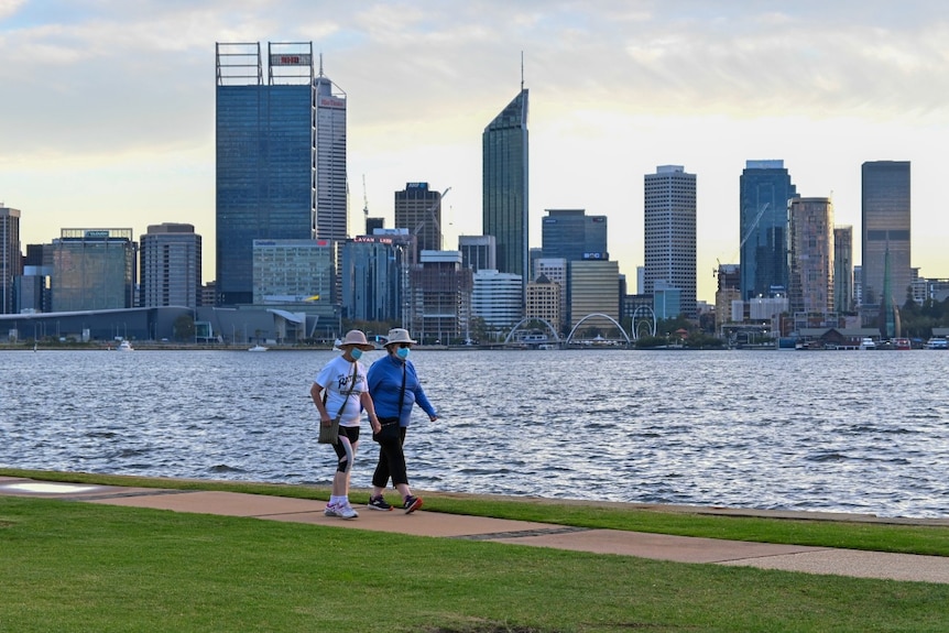 Two woman walking on South Perth foreshore with the Perth city skyline in the background.