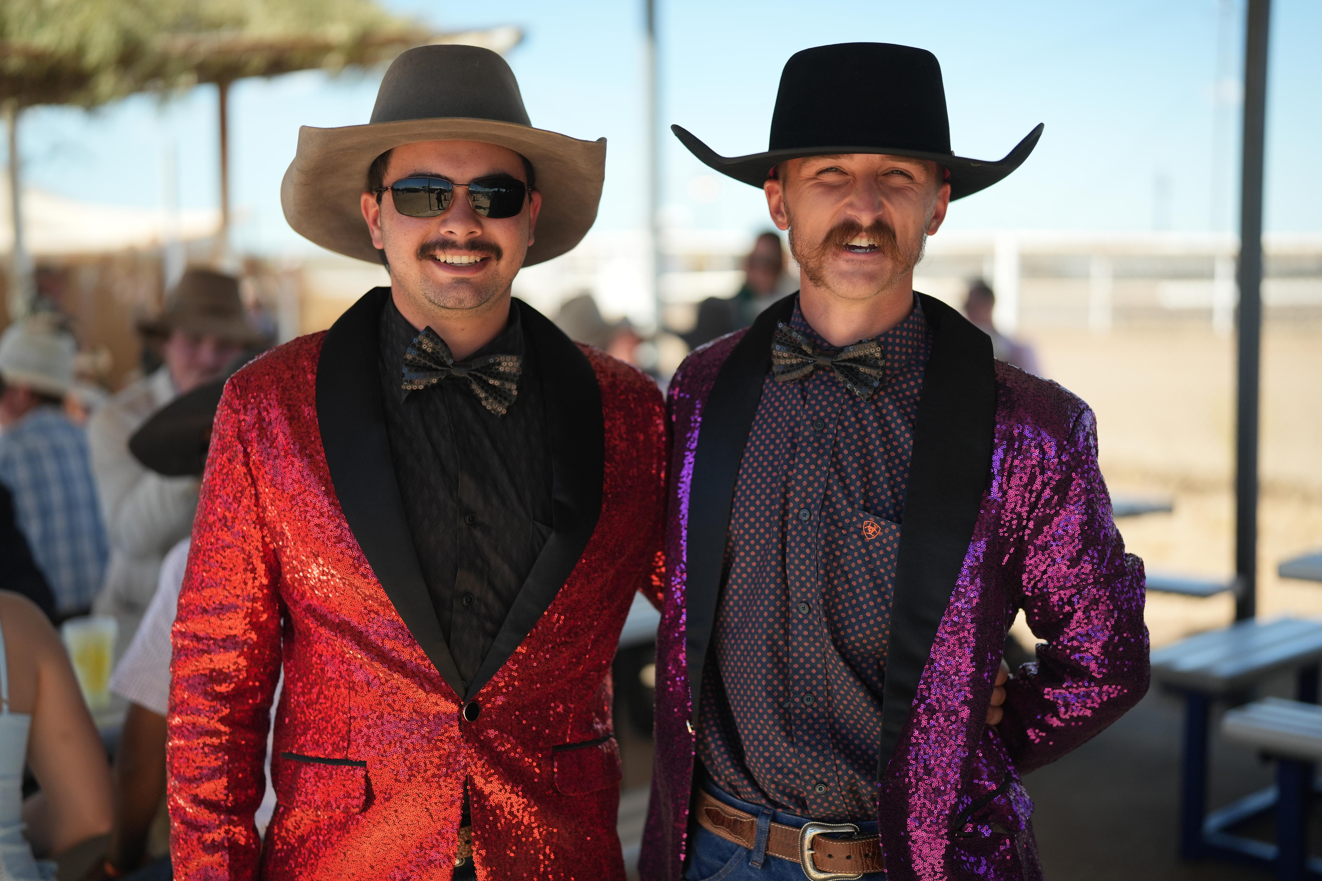 Two men in cowboy hats and sparkly suits smile
