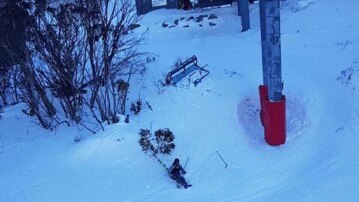 Skier falls as chairlift dislodges off cable.