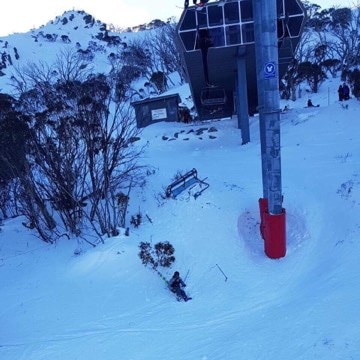 Skier falls as chairlift dislodges off cable.