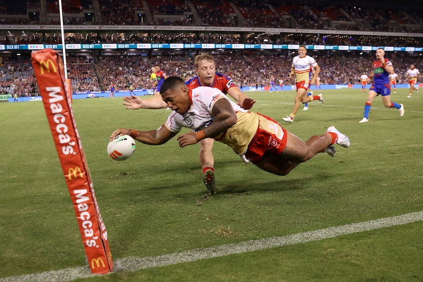 A player dives in to score a try for the Dolphins
