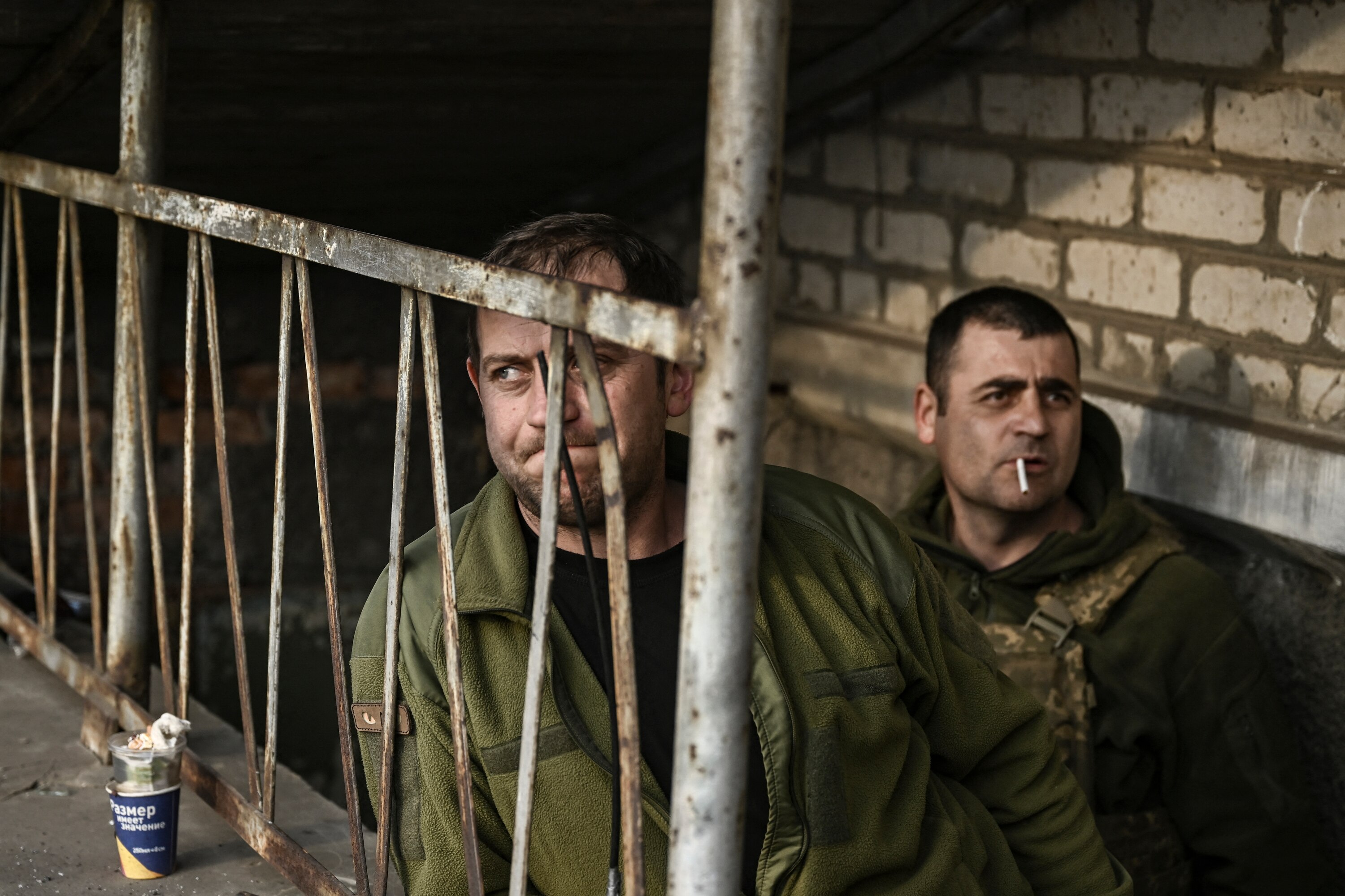 Ukrainian servicemen stand at the entrance of a basement shelter near Bakhmut.