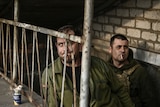 Ukrainian servicemen stand at the entrance of a basement shelter near Bakhmut.