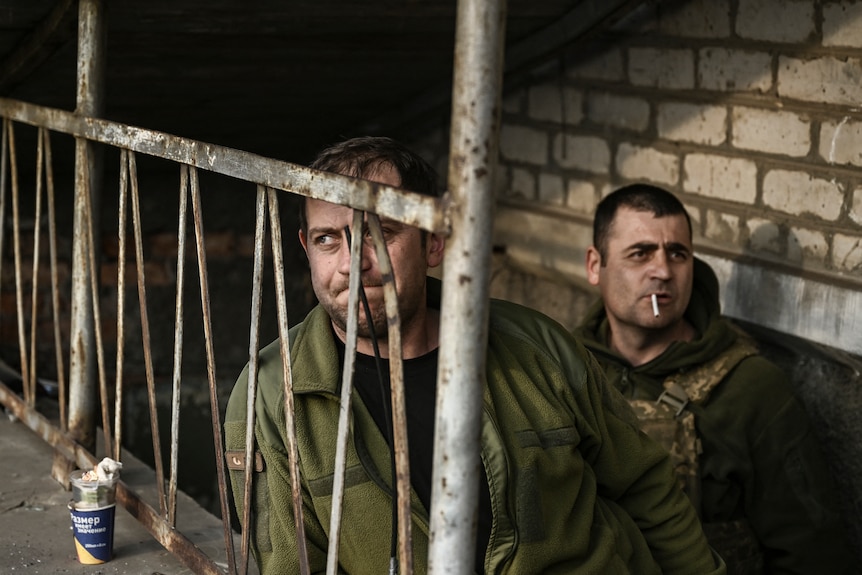 Ukrainian servicemen stand at the entrance of a basement shelter near Bakhmut.