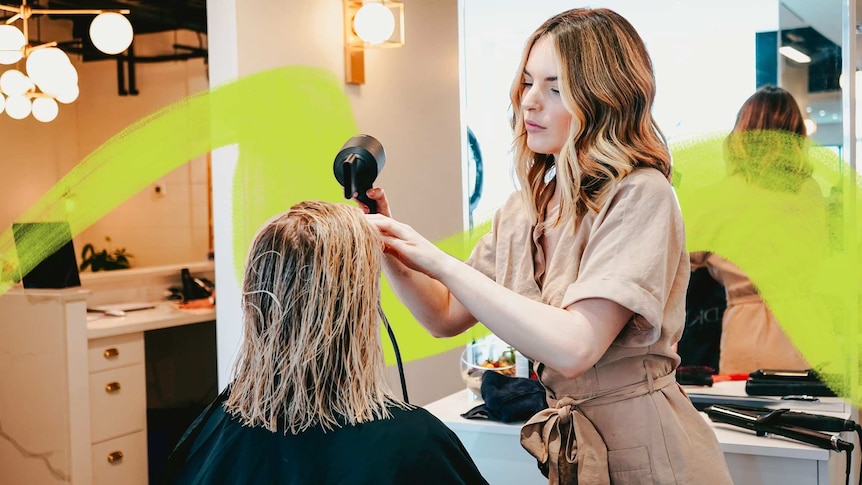 Woman doing another woman's hair in a salon for a story about the emotional labour of jobs like hairdressing.