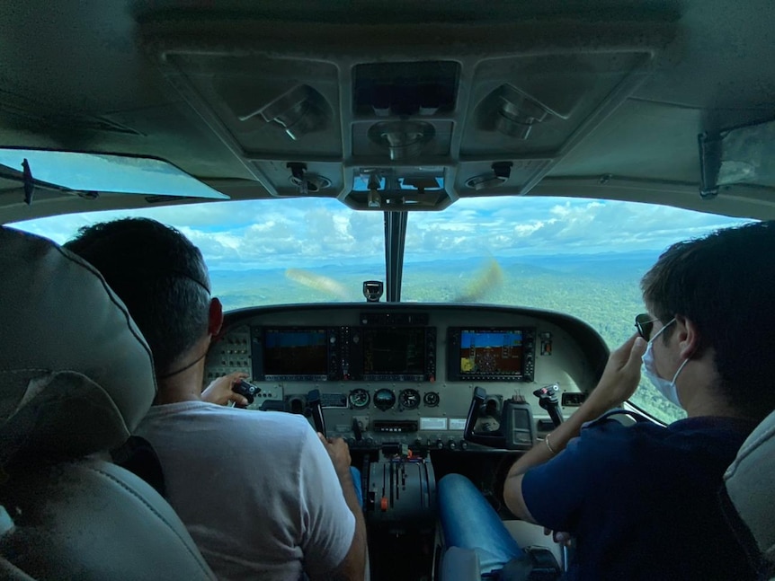 The view from the back seat of a small aircraft flying over the rain forest 