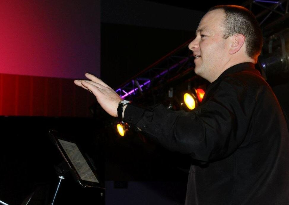 teacher damien woods conducting a musical item