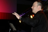 teacher damien woods conducting a musical item