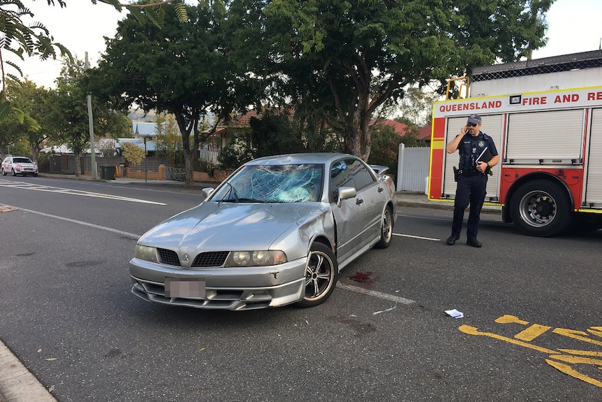 Smashed up car in front of fire fighting truck.