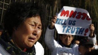 Liu Guiqiu, whose son was onboard Malaysia Airlines flight MH370, cries outside Malaysian embassy in Beijing on March 8, 2015